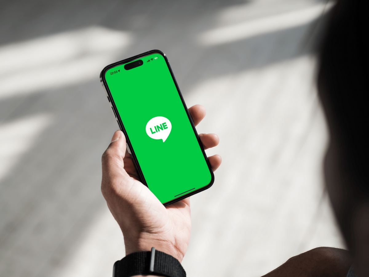 LINEアプリが表示されたスマートフォンを持つ手